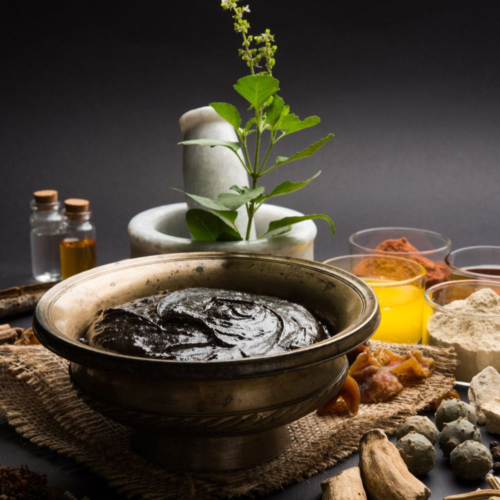 Traditional Ayurvedic herbs and ingredients on a dark background